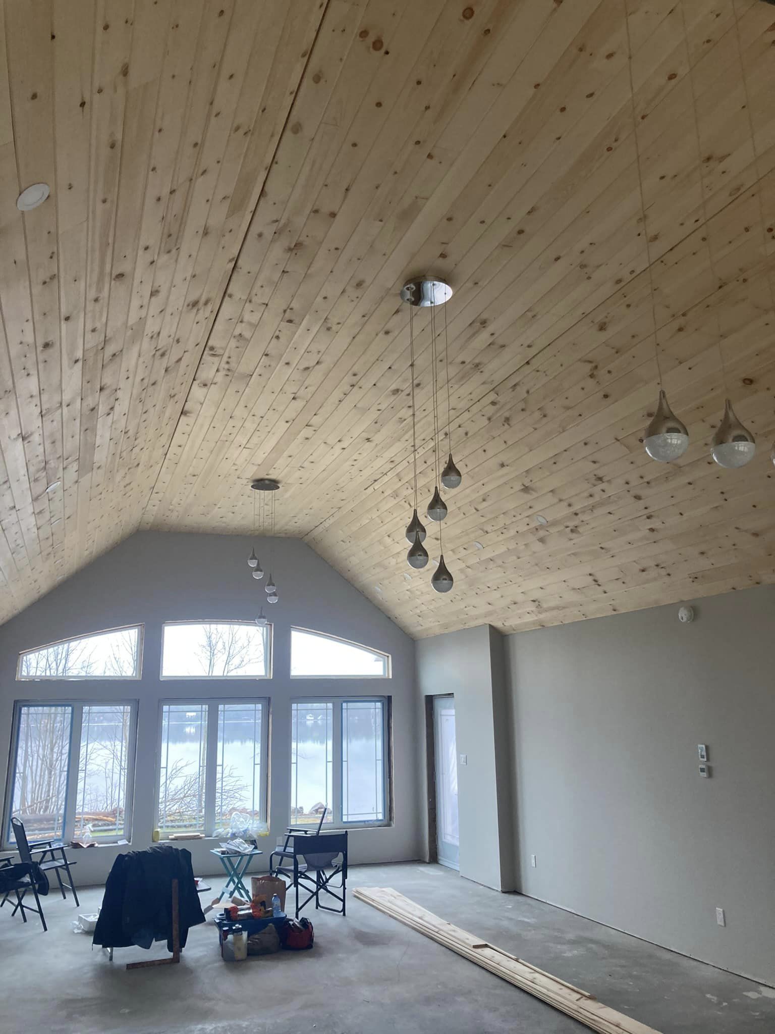 Pine Ceiling in long room with triple window bay window and two chairs